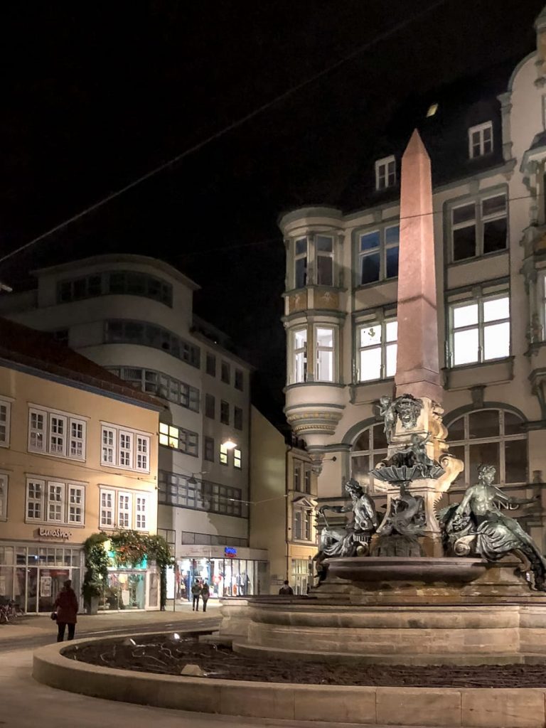 Am Angerbrunnen - Geschäftshaus Schellhorn, Neuwerkstraße 2, Erfurt im Hintergrund, bei Nacht.