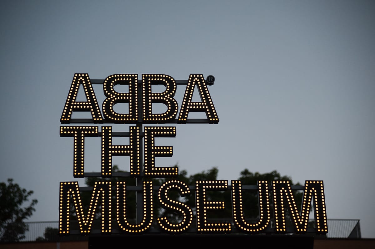 ABBA The Museum in Stockholm - Leuchtschrift am Eingang des Museums während der blauen Stunde
