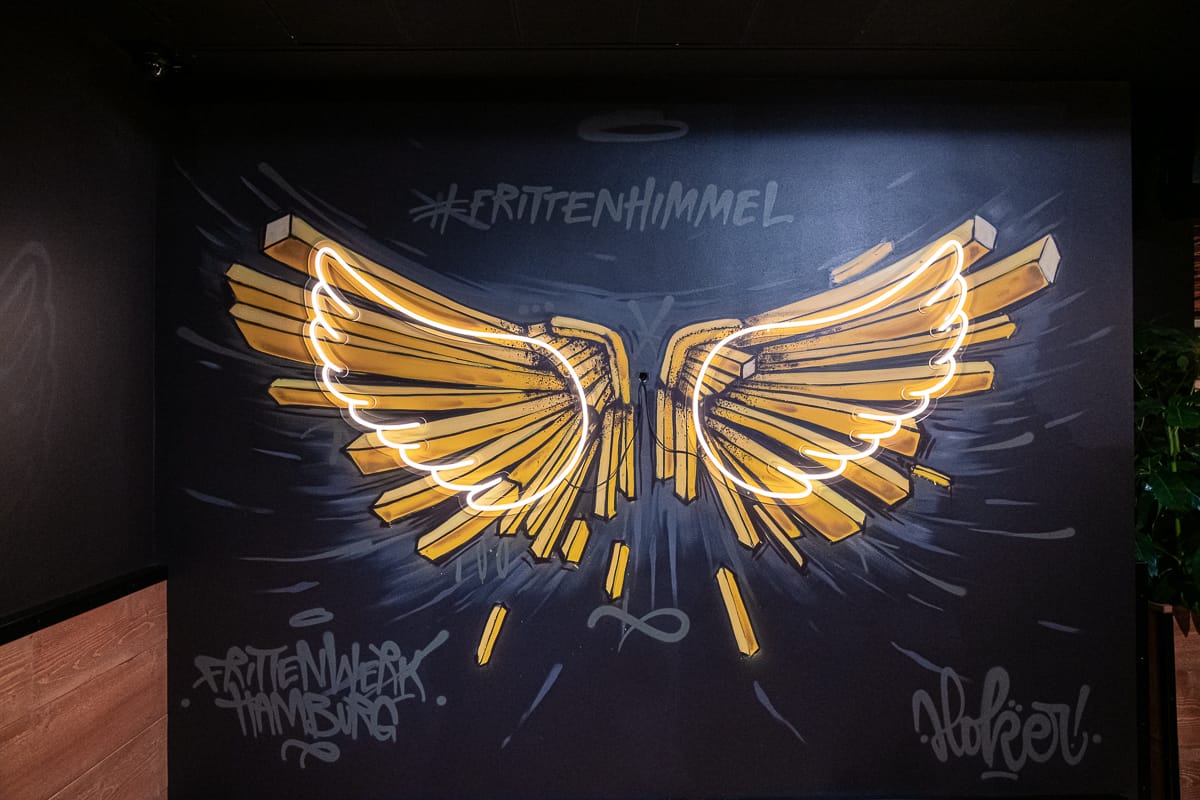 Instagramable Spot - Frittenhimmel-Graffito mit Engelsflügel aus Pommes