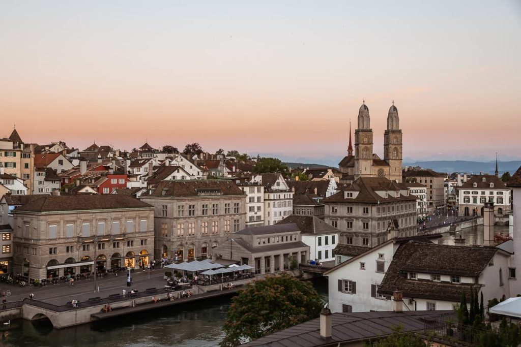 Sonnenuntergang in Zürich mit Großfrauenmünster und den Alpen im Hintergrund 