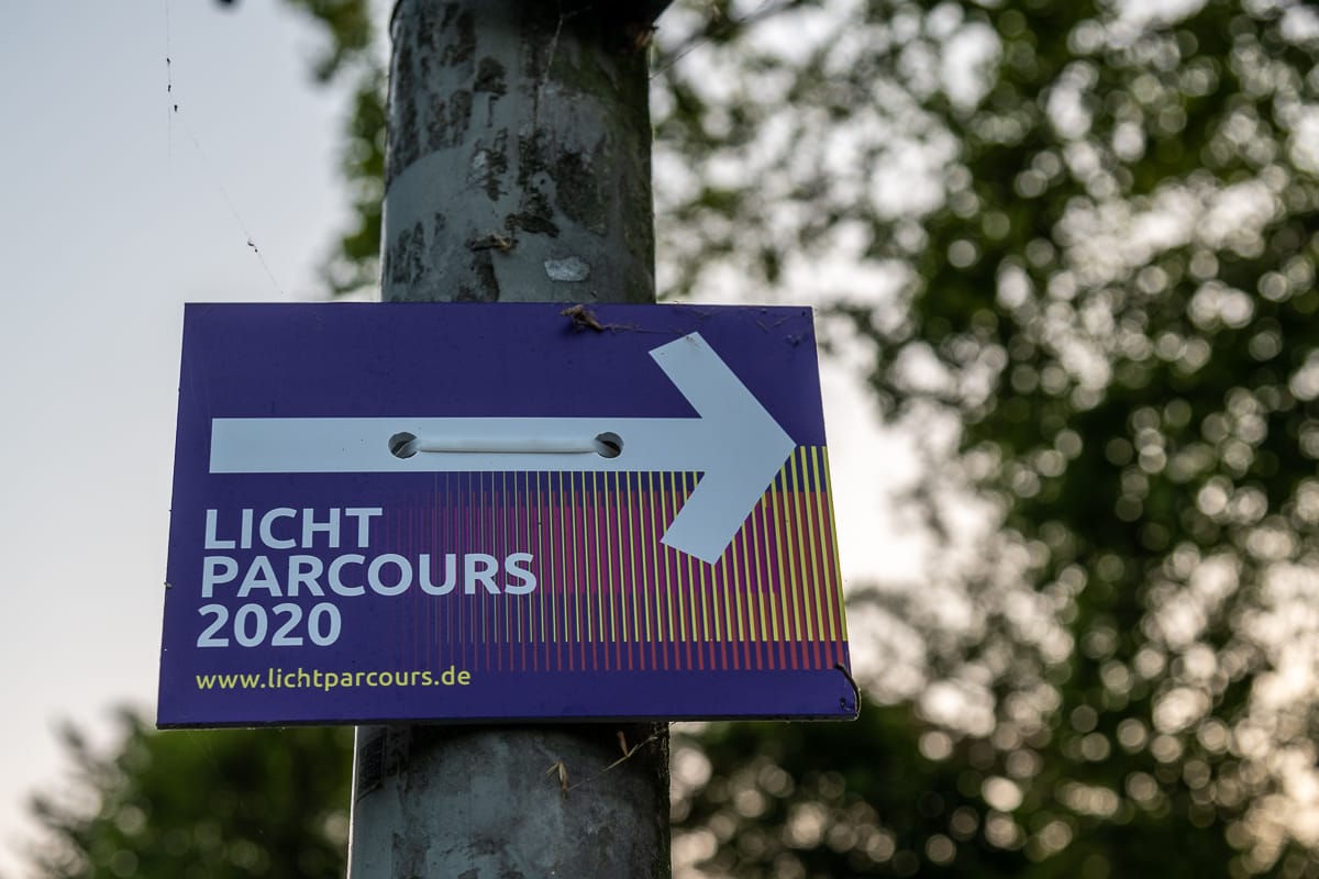 Wegweiser für den Lichtparcours 2020 inkl. Pfeil nach rechts und URL zur Website www.lichtparcours.de.