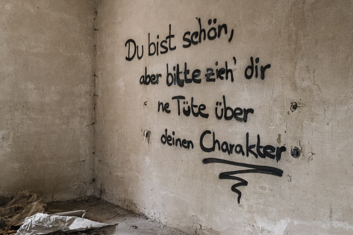 Botschaft "Du bist schön, aber bitte zieh' dir 'ne Tüte über deinen Charakter" als Graffiti an einer Wand in einem Lost Place im Harz - März 2022.