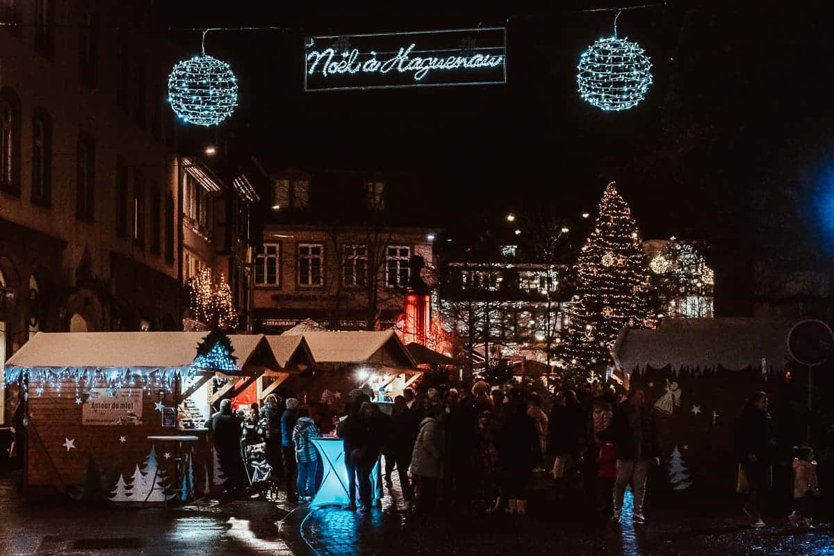 Eingang zum Weihnachtsmarkt Haguenau mit Schriftzug "Noël à Haguenau" sowie Weihnachtsbaum im Hintergrund. 