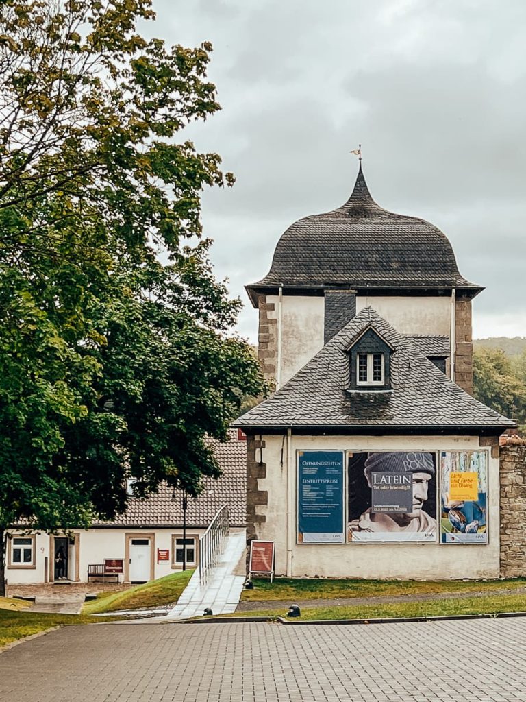 Eingang zum Klostergelände Kloster Dalheim mit Plakat zur Sonderausstellung Latein. Tot oder Lebendig.