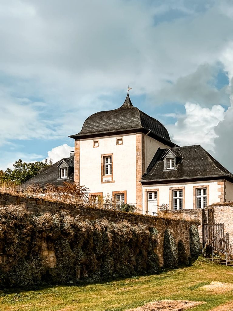 Barockes Eingangsgebäude mit Mauer zum oben gelegenen Prälaturgarten.