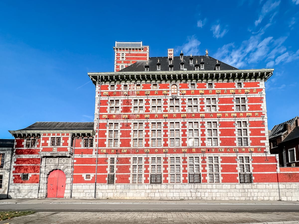 Frontalansicht von Grand Curtius von der Straße aus. Kleines dazugehöriges Gebäude links daneben mit großem Hoftor.