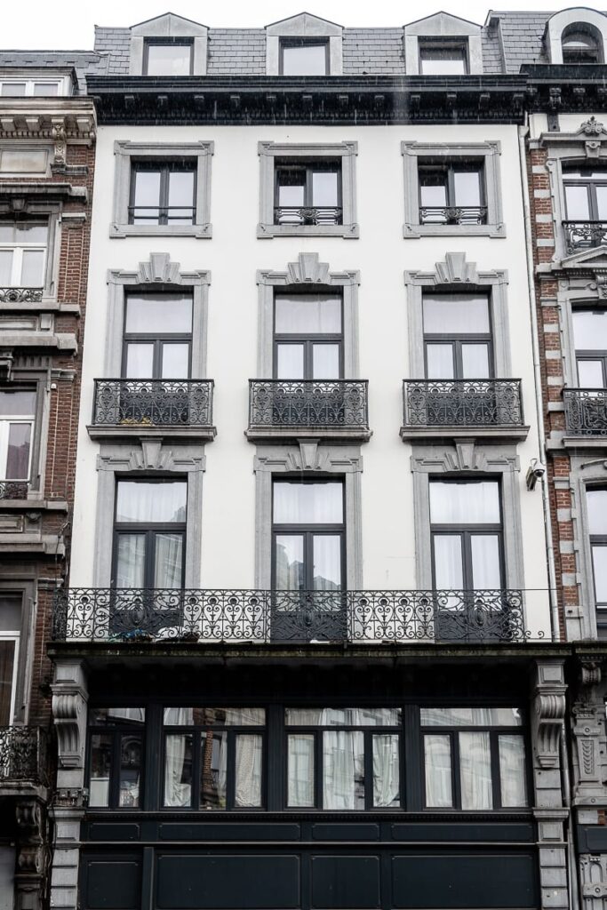 Hausfront des Geburtshauses von Georges Simenon, Rue Léopold 24 in Lüttich, Gründerzeithaus, 4-5-stöckig, drei Fenster breit, nach oben hin kleiner werdende Fenster. 