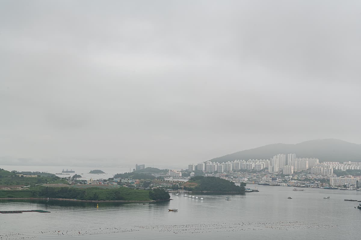 Hafenstadt Yeosu im Süden von Jeollanam-do von oben mit vorgelagerten Inseln bei schlechtem Wetter und vielen grauen Wolken.