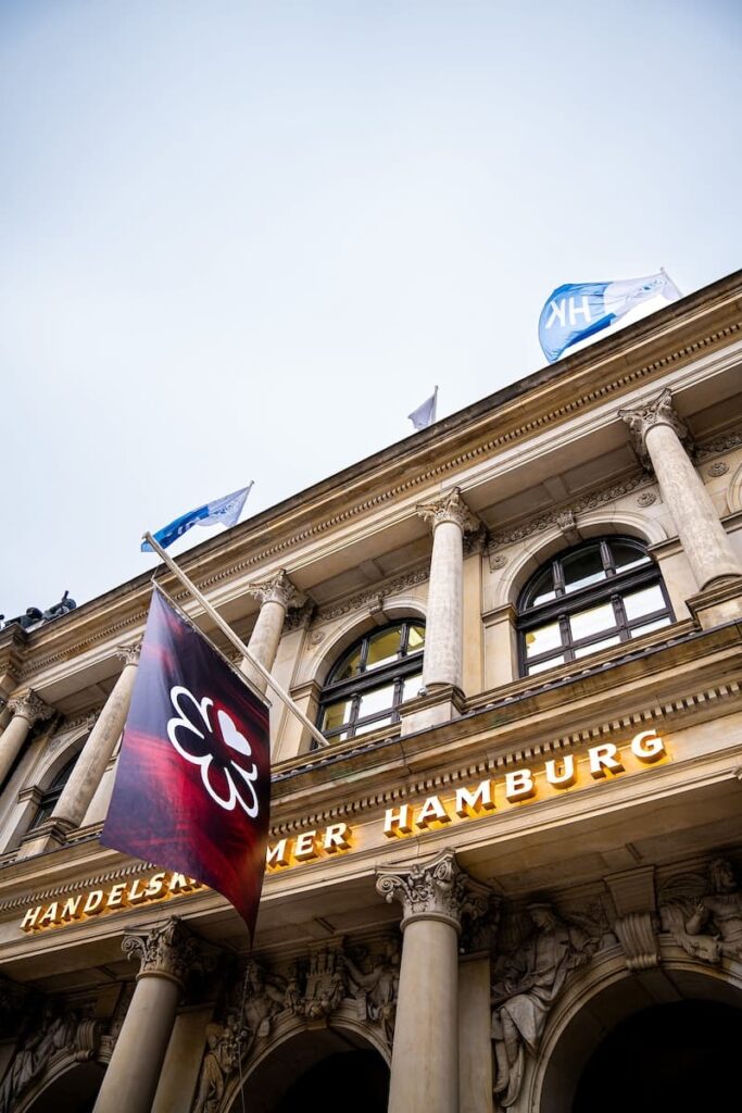 Handelskammer Hamburg von außen, Schriftzug über de Eingang "Handelskammer Hamburg", Fahne mit dem Michelin-Logo hängt darüber und kündigt die Veranstaltung für die Selektion zum Michelin Guide 2024 an. 