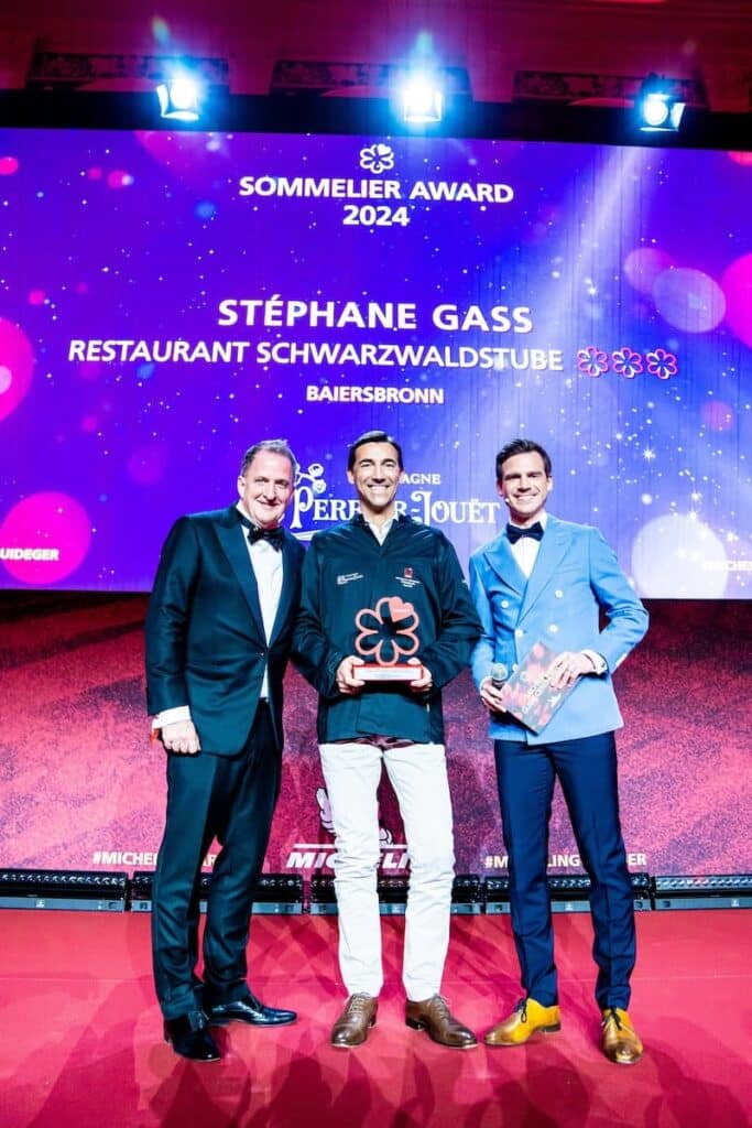 Michelin Sommelier Award 2024 - Gruppenbild mit Laudator Holger Möller (links), Stéphane Gass mit Award und Moderator Aljoscha Höhn (rechts).