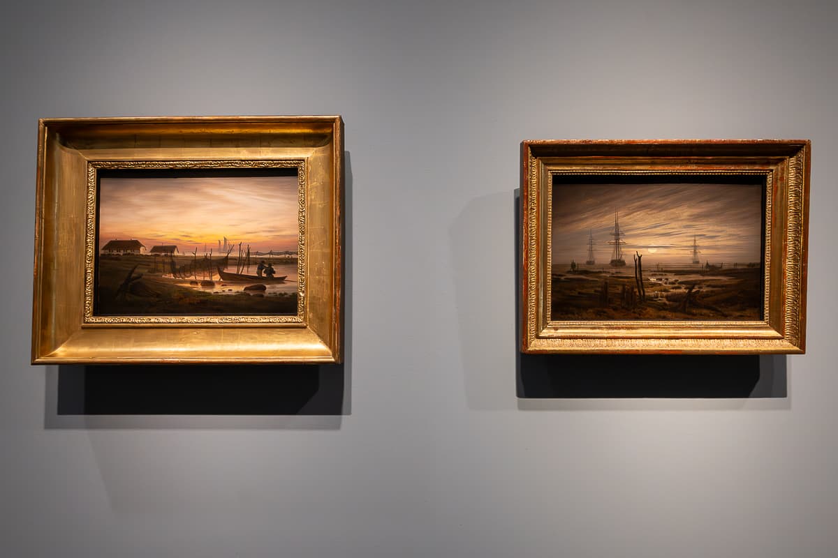 Zwei kleine Bilder mit teils großem Goldrahmen, querformatig, Caspar David Friedrich, Kunsthalle Hamburg. Links: Küstenlandschaft im Morgenlicht, um 1817, Öl auf Leinwand, Museum Behnhaus Drägerhaus, Lübeck.
Rechts: Schiffe auf der Reede, um 1818, Öl auf Leinwand, Museum Behnhaus Drägerhaus, Lübeck, Leihgabe aus Berliner Privatsammlung.