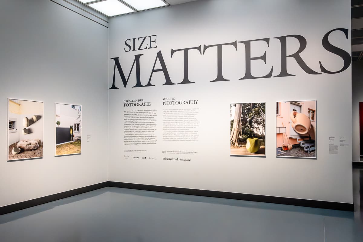 Erster Raum der Ausstellung "Size Matters" im Kunstpalast Düsseldorf mit ersten Bildern unter dem großen Schriftzu und rechts neben dem Einleitungstext, auf der Wand links davon auch zwei Fotos.