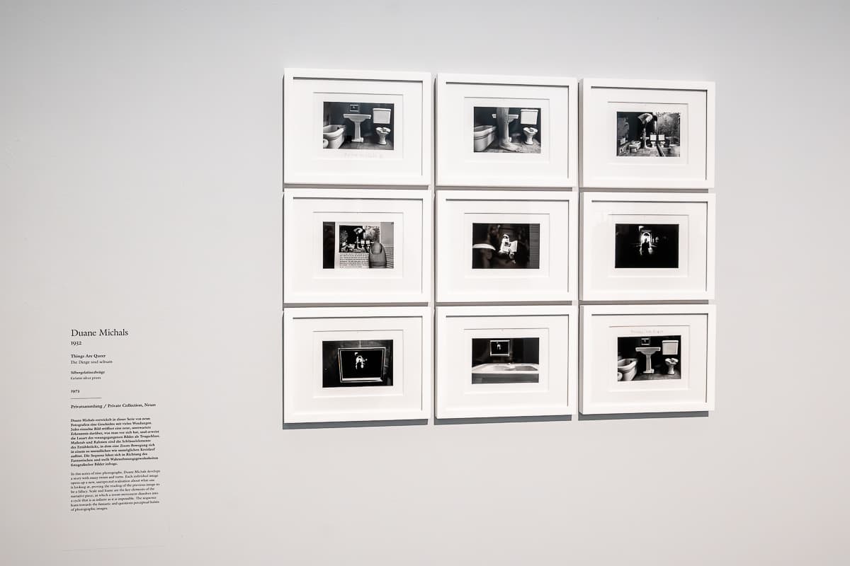 Bilderfolge aus 9 Bildern in 3x3 Reihen in Size Matters, Kunstpalast Düsseldorf gehängt. Schrift daneben mit Beschreibung und Detail. Bilder sind von Duane Michals, Things Are Queer, 1973, 9 Silbergelatineabzüge, je 12,5x18 cm, aus einer Privatsammlung. Es wird eine Geschichte erzühlt, in der immer wieder eines der vorherigen Bilder in einer Reihe Teil der nachfolgenden Reihe ist. 