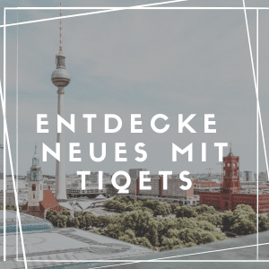 Eine Stadtansicht mit dem Berliner Fernsehturm und den umliegenden Gebäuden, mit einer Mischung aus moderner und historischer Architektur. Im Vordergrund sind Bäume zu sehen. Der überlagerte Text in deutscher Sprache lautet „Entdecke Neues mit Tiqets“, eingerahmt von einem weißen geometrischen Rand.